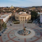 Aerial view of Kutaisi with its central square and Colchis fountain, surrounded by historic buildings. In the background, Bagrati Cathedral gently overlooks the city.