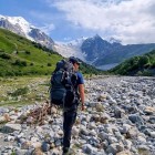 Upper glacial valley of Adishi in Svaneti, shaped by Caucasus glaciers, with moraines, debris and meltwater streams forming a dynamic landscape.