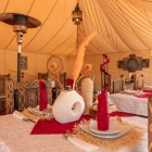 Elegant restaurant inside a luxury camp in Merzouga, with Berber-style décor, soft lighting and a refined atmosphere in the heart of the Moroccan Sahara.