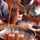 Tasting in the village of Khamlia of the classic Moroccan tea prepared with green tea, fresh mint leaves and plenty of sugar.