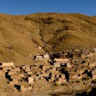 Small Berber village in the High Atlas Mountains, along the road to Tizi n'Tichka, surrounded by stone houses and arid Moroccan landscapes.