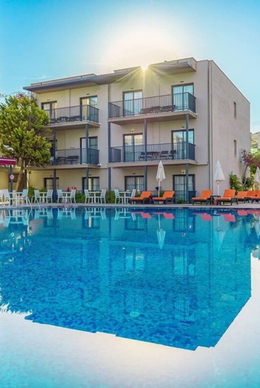 Large turquoise swimming pool surrounded by sun loungers and relaxing terraces: Bodrum Beach Resort offers a perfect summer atmosphere by the Aegean Sea.