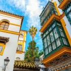 Elegant Andalusian balconies overlook Seville's historic streets, where Moorish architecture, vibrant colors and centuries-old traditions create a unique atmosphere.