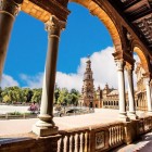 From the elegant galleries of Plaza de España unfolds one of Seville's most iconic views, featuring ornate bridges, colorful ceramics and Andalusian charm