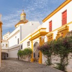 Along Seville's whitewashed streets, an elegant historic building reveals the authentic soul of Andalusia, surrounded by blooming courtyards and timeless charm.