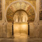 The magnificent mihrab of Cordoba's Mosque-Cathedral captivates with golden mosaics and exquisite decorations, showcasing the greatness of Islamic art in Spain.