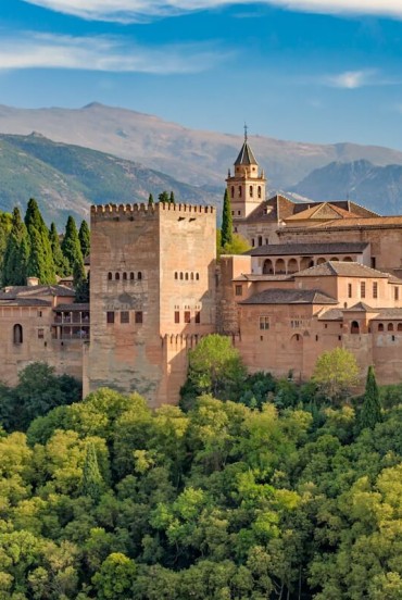 The Alhambra overlooks Granada with its walls, towers and Nasrid palaces beneath the Sierra Nevada. A masterpiece of Islamic architecture and Andalusia's timeless icon.