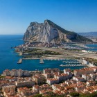 The Rock of Gibraltar rises above the coastline with its impressive limestone cliffs, overlooking the harbour and the Strait linking the Mediterranean to the Atlantic Ocean.