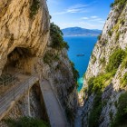The walkway carved into the Rock of Gibraltar winds between towering limestone cliffs, revealing breathtaking views across the Strait between Europe and Africa.