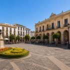 Plaza de España is the heart of Ronda, surrounded by elegant historic buildings, arcades and manicured gardens, with the Blas Infante statue at its center.