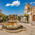 Plaza del Socorro features its elegant Neo-Baroque church and historic fountain, just steps from Ronda's famous Bullring, a landmark of Spain's equestrian tradition.