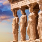The Porch of the Caryatids adorns the Erechtheion with six graceful female figures carved in stone. At sunset, this Acropolis masterpiece reveals the elegance and legacy of ancient Greece.