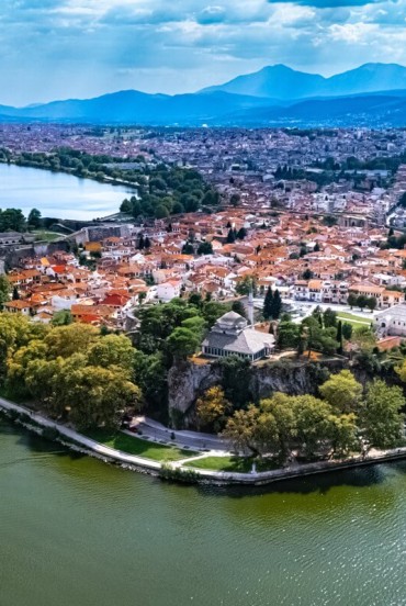 Aerial view of Ioannina's historic peninsula, surrounded by the waters of Lake Pamvotida. Ancient walls, the castle and lush greenery create one of Epirus' most captivating landscapes.