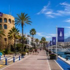 The historic watchtower overlooks the entrance to Puerto Banús, surrounded by luxury yachts, palm trees and scenic waterfront promenades in glamorous Marbella.