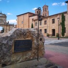 A stone monument welcomes visitors to Sahagún's historic center, surrounded by remarkable buildings that reflect the town's rich heritage along the Camino de Santiago.