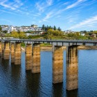 Panoramic view of Portomarín on the Miño River, with the bridge crossing the Belesar reservoir and the historic village, a landmark stop on the Santiago Way.