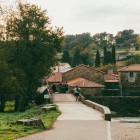The historic bridge over the Furelos River leads pilgrims onto the Camino de Santiago, framed by ancient stone houses that preserve the authentic soul of Melide.