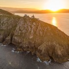 Cape Finisterre Lighthouse overlooks the cliffs of the Costa da Morte at sunset, where the Camino de Santiago reaches its evocative finale on the Atlantic Ocean.