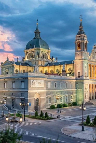 Almudena Cathedral dominates central Madrid with its Neoclassical façade, twin towers and dome, blending historicist forms in harmony with the nearby Royal Palace.