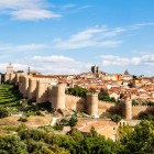 A breathtaking panorama showcases the entire fortified walls of Ávila, a UNESCO World Heritage masterpiece enclosing the historic centre with its crenellated towers and monumental gateways.