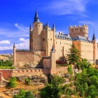 The medieval Alcázar of Segovia rises above a rocky hilltop. Towers, stone walls and slate roofs tell centuries of history in the heart of Castile.