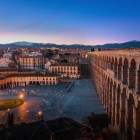 At sunset, the Roman Aqueduct of Segovia overlooks Plaza Oriental with its impressive granite arches, creating one of Castile's most evocative views.
