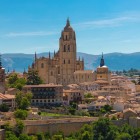 Segovia Cathedral dominates the city's skyline with its elegant bell tower and refined Gothic architecture, framed by terracotta rooftops and the Sierra de Guadarrama.