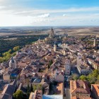 An aerial view reveals the charm of Segovia, where medieval streets, terracotta rooftops and historic landmarks create a unique landscape crowned by the majestic Cathedral.