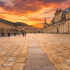 The Royal Monastery of San Lorenzo de El Escorial, a UNESCO World Heritage Site, glows at sunset, highlighting the austere Herrerian style and the grand vision of King Philip II.