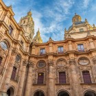The cloister of the Pontifical University of Salamanca blends Baroque elegance with Renaissance harmony. Arcades, columns and the great dome enhance one of Spain's most prestigious academic complexes.
