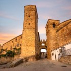 The Puerta de Santiago leads into Trujillo’s medieval quarter through an arched passage, flanked by robust stone towers belonging to the ancient defensive walls.