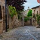 A cobbled street crosses Trujillo’s historic centre, lined with ancient stone houses, irregular walls and doorways preserving Extremadura’s medieval urban layout.