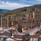The village of Guadalupe gathers around the Royal Monastery of Santa María, a Gothic-Mudéjar complex rising above white rooftops, framed by Extremadura’s hills.
