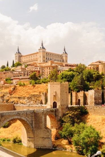 Alcántara Bridge crosses the Tagus below Toledo, dominated by the Alcázar and medieval walls that recount centuries of history in Spain’s remarkable City of Three Cultures.