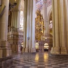 Mighty Gothic pillars define Toledo Cathedral’s naves; the geometric floor guides the eye towards the gilded altarpiece, framed by arches and stained-glass windows.