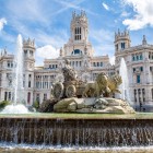 The Fuente de Cibeles dominates the square with the goddess’s chariot drawn by lions; behind it, the Neo-Gothic towers of Palacio de Cibeles evoke monumental Madrid.