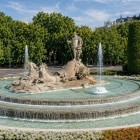 The Neptune Fountain celebrates the god of the sea riding a chariot drawn by sea horses; concentric basins, water displays and gardens enhance its Neoclassical setting in Madrid.