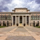 The Prado Museum welcomes visitors with Juan de Villanueva’s Doric portico: its Neoclassical façade, marked by columns and statues, safeguards centuries of European art.