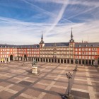 Plaza Mayor reveals the heart of Habsburg Madrid: continuous arcades, brick façades and the towers of Casa de la Panadería surround the equestrian statue of Philip III.