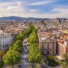 Seen from above, La Rambla crosses the heart of Barcelona amid plane trees, 19th-century buildings and lively squares, connecting Plaça de Catalunya with Port Vell through the historic centre.