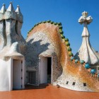 The terrace of Casa Batlló reveals Gaudí’s organic world: the sculptural chimney, trencadís surfaces and four-armed cross enliven the dragon-inspired roof.
