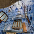 Casa Batlló’s light well rises towards the light through graduated blue ceramic tiles, sinuous windows and balconies reflecting Gaudí’s organic architectural language.