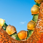 The roof of Casa Batlló forms an undulating profile covered with orange and green ceramics; glazed spheres accentuate its organic shapes inspired by a dragon’s back.