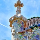 At the top of Casa Batlló, the trencadís-covered tower culminates in a four-armed cross, while the scale-like roof evokes the dragon of the Catalan legend of Sant Jordi.