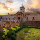 Montjuïc Castle retains the appearance of an 18th-century fortress: stone bastions, a moat, an access bridge and defensive geometry recount Barcelona’s military past.