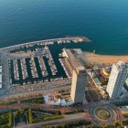 Port Olímpic, Ciutadella and Vila Olímpica, with docks, breakwaters and twin towers overlooking the Mediterranean at dawn on a summer day.