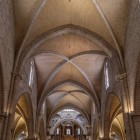 The nave of Valencia Cathedral leads towards the altar through slender pillars, pointed arches and ribbed vaults, reflecting the elegance of 13th-century Gothic architecture.