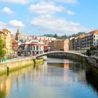 The Bilbao Estuary crosses the Old Town amid bridges, tree-lined promenades and colourful façades, leading towards Mercado de la Ribera, a hub of city life.
