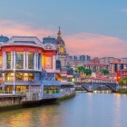 Mercado de la Ribera and San Antón Church line the Bilbao Estuary, amid historic architecture, bridges and colourful façades in the heart of the Old Town.