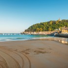 From La Concha Beach, the view reaches Mount Urgull, crowned by the Sagrado Corazón statue and the fortifications of Castillo de la Mota.